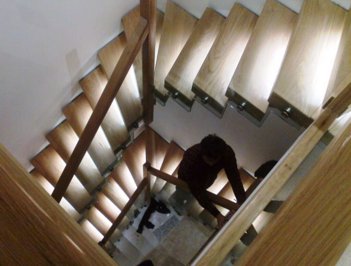 A modern floating wooden staircase with glass balustrade installed in a house renovation on the Isle of Wight